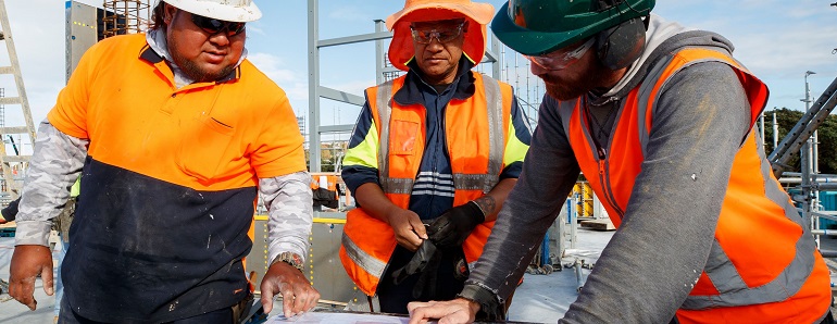 3 pacific construction workers looking at a plan